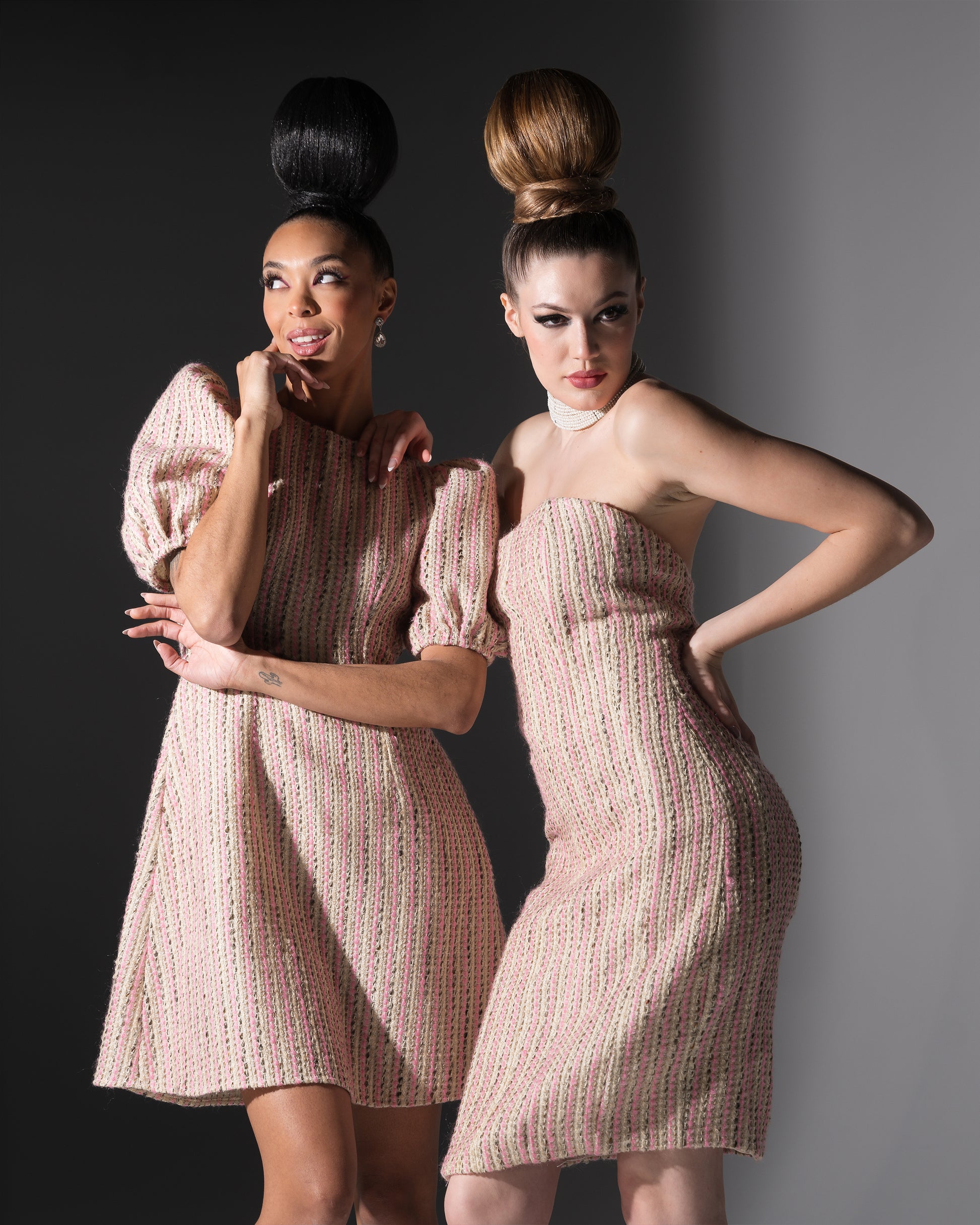 Two women wearing matching dresses against a gradient background