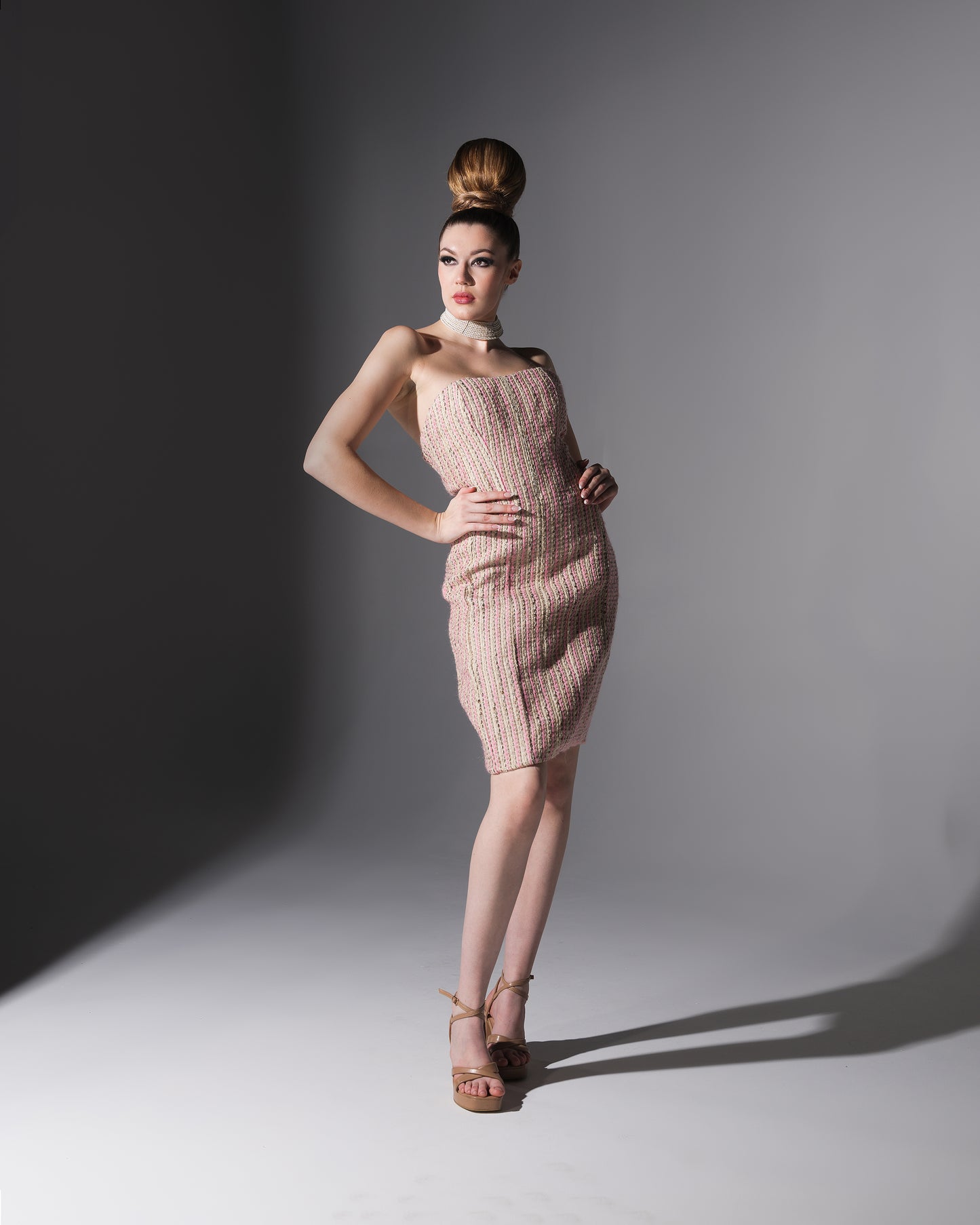 Model wearing a pink ribbed dress against a gray background